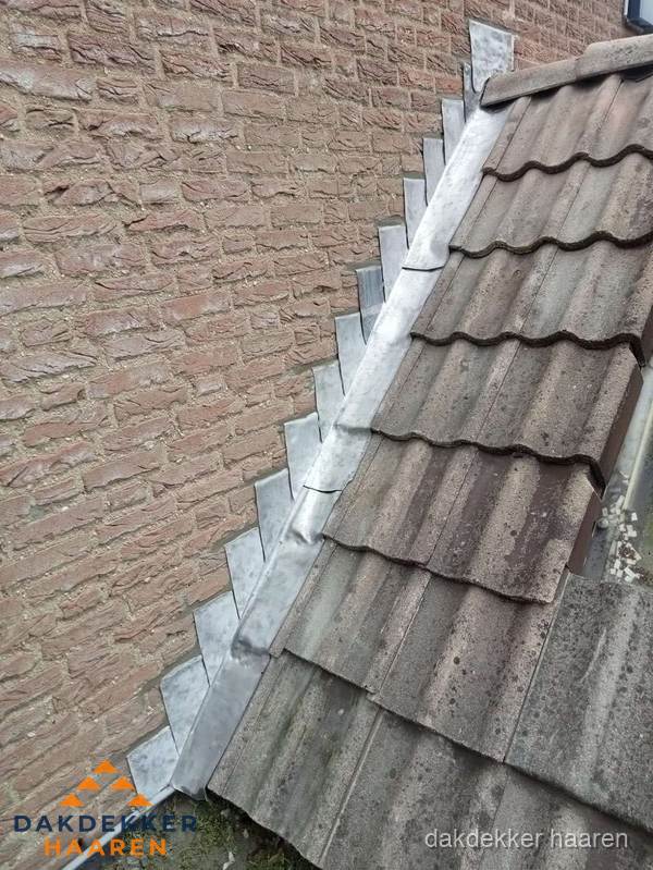 Loodslabben langs dakaansluiting bij bakstenen muur in Haaren