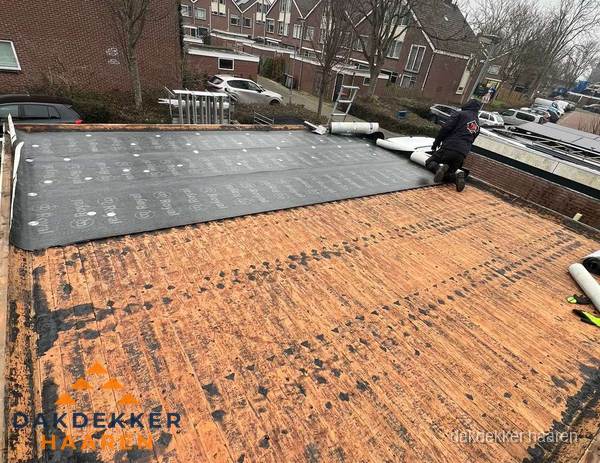 Dakdekker legt onderlaag op plat dak met houten constructie in Haaren