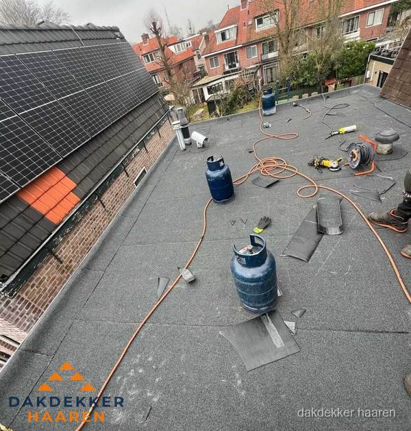 Daklekkage repareren met brandgereedschap op plat dak in Haaren