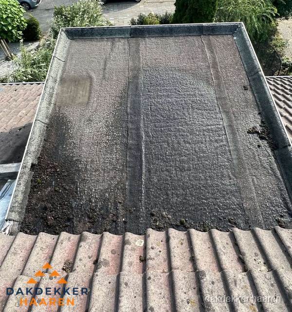 Verouderd plat dak met bitumen en slijtage voor lekkage inspectie in Haaren