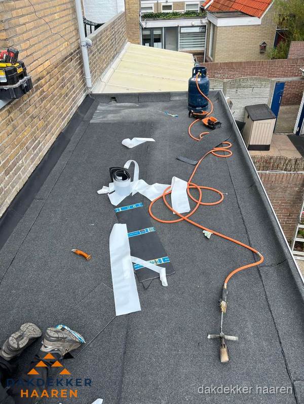 Dakdekkers bezig met bitumen dakbedekking in Haaren