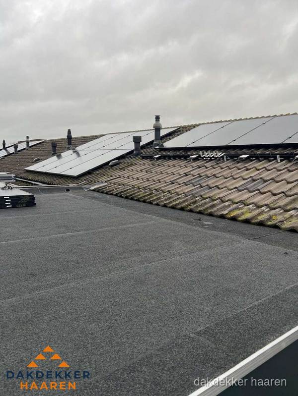 Bitumen dakbedekking op plat dak met aansluitend pannendak en zonnepanelen in Haaren