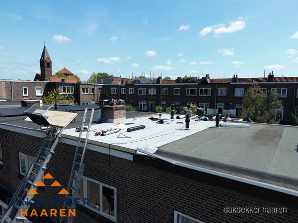 Dakdekkers aan het werk op plat dak in Haaren
