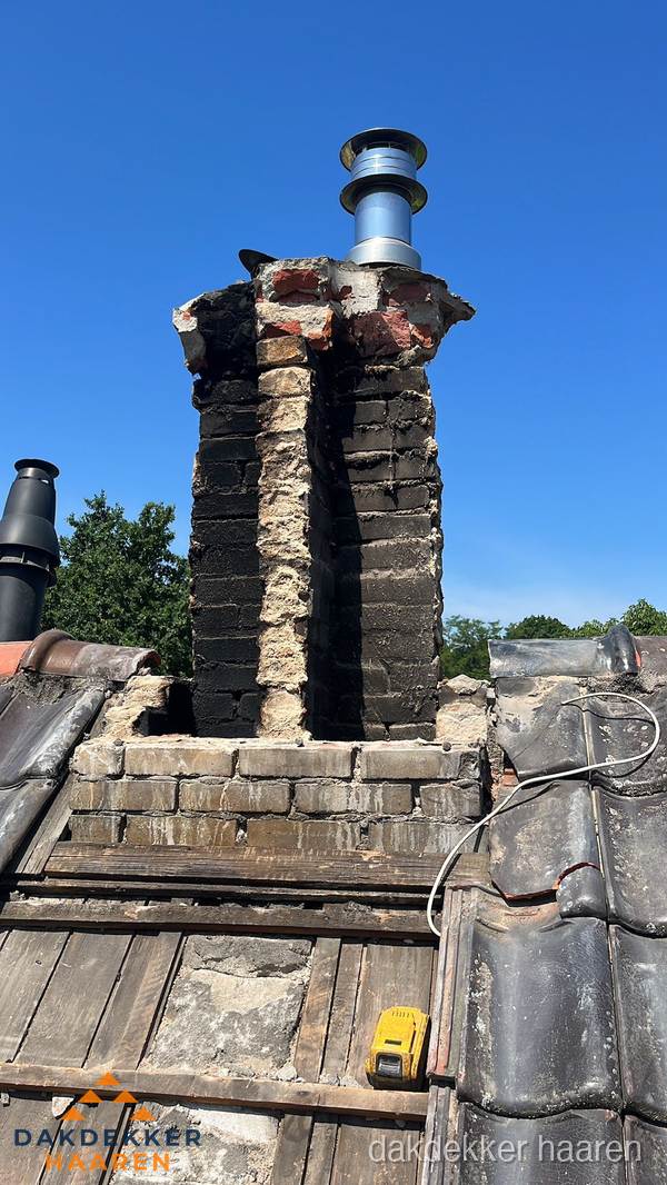 Beschadigde schoorsteen met nieuwe rookgasafvoer op oud dak in Haaren