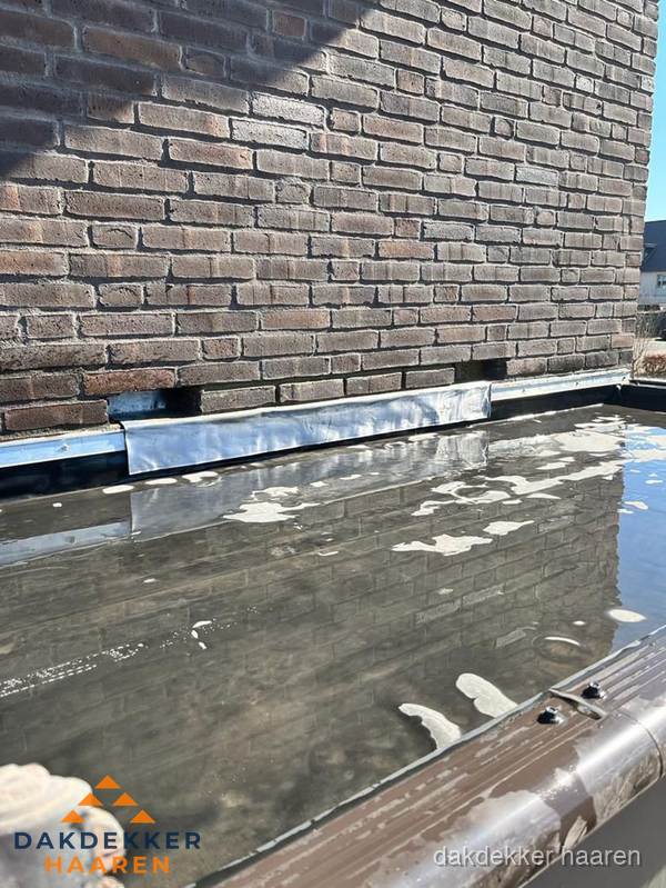 Stilstaand water op plat dak door slechte afwatering in Haaren
