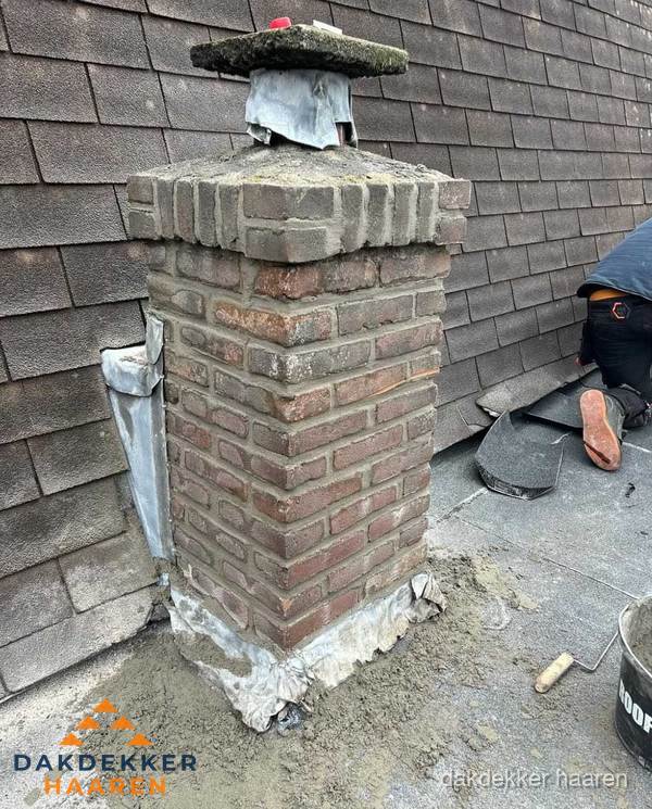 Schoorsteen reparatie met lood en voegwerk op leien dak in Haaren