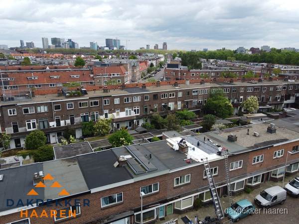 Spoed dakdekker aan het werk op plat dak in woonwijk Haaren