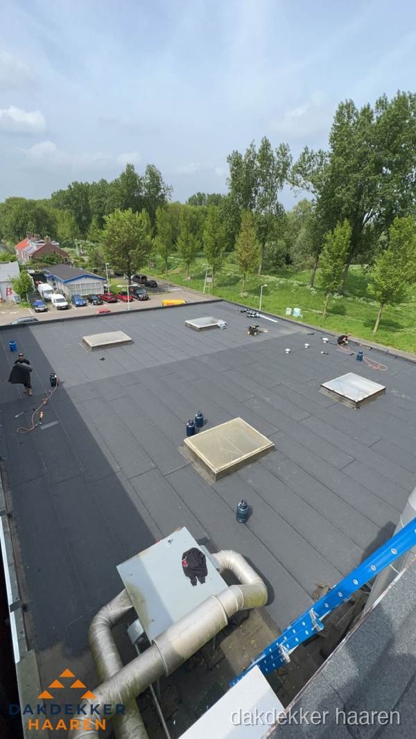 Dakdekker aan het werk op groot plat dak met bitumen in Haaren Dakdekker aan het werk op groot plat dak met bitumen in Haaren