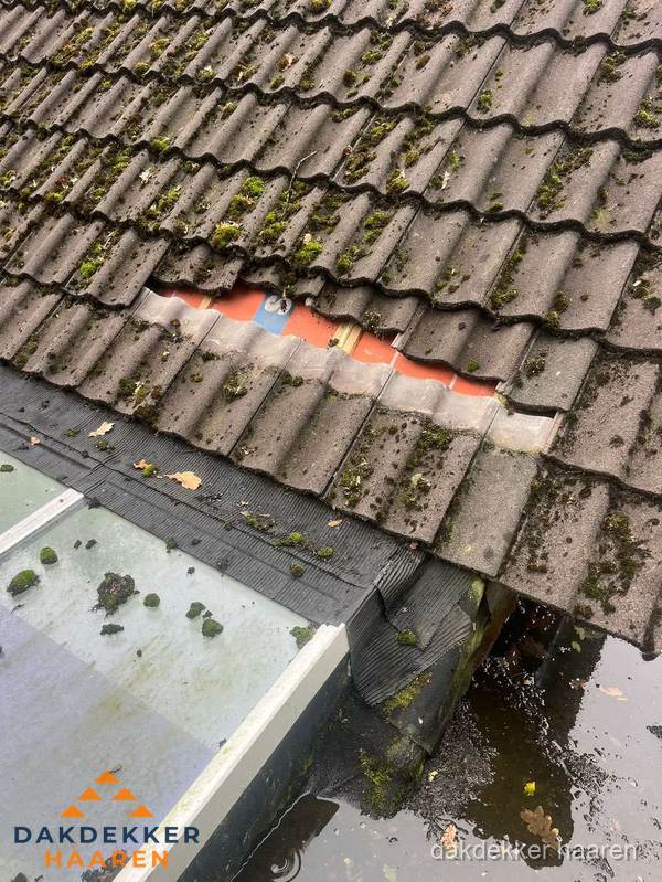 Beschadigd pannendak met ontbrekende dakpannen voor reparatie in Haaren