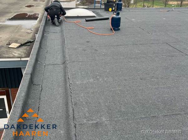 Dakdekker repareert bitumen dakbedekking op groot plat dak in Haaren Dakdekker repareert bitumen dakbedekking op groot plat dak in Haaren