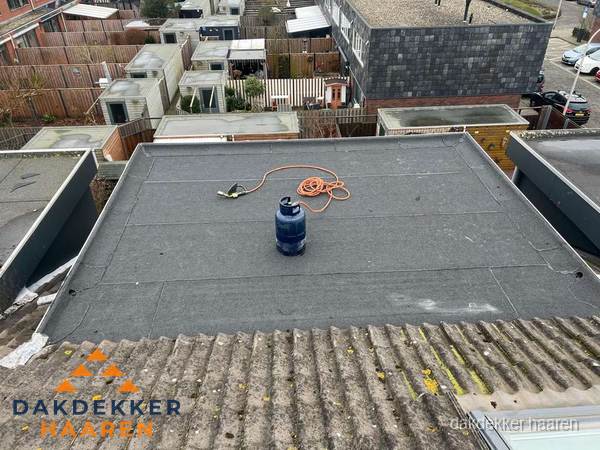 Plat dak met nieuwe bitumen dakbedekking en brandgereedschap in Haaren